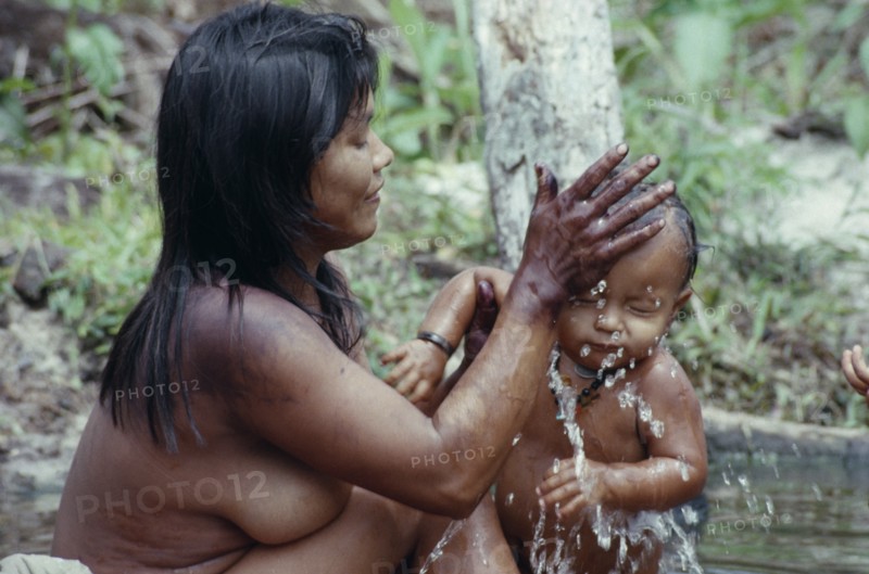 COLOMBIA, North West Amazon, Tukano Indigenous People, Young Makuna mother washing her baby at the river port. Tukano  Makuna Indian North Western Amazonia family cleaning bathing American Babies Colombian Columbia Hispanic Indegent Kids Latin America Latino Mum South America Tukano