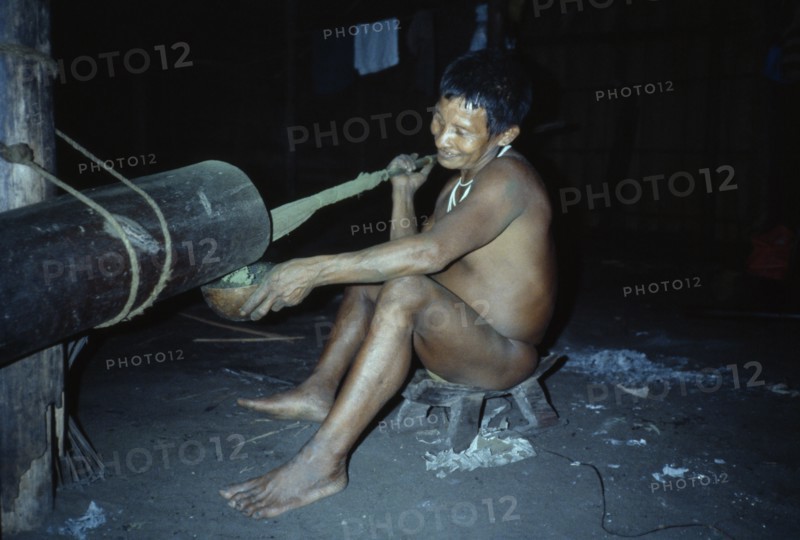 COLOMBIA, North West Amazon, Tukano Indigenous People, "Visiting Maku nomadic hunter pounding coca leaves to very fine powder  pours powder into a gourd, mixes with yarumo ash and puts into mouth. Maku nomadic hunter Indian North Western Amazonia Vaupes "