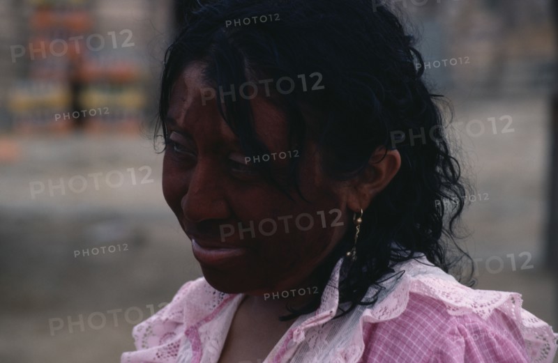 COLOMBIA, Guajira Peninsula, Guajiro Indians, Head and shoulders portrait of Guajira woman with face painted dark red (Achiote fruit) and black with a mixture of goat's fat and charcoal as protection against sun and strong sea winds. Wayu Wayuu Guajiro Amerindian Arawakan Colombia-Venezuela border