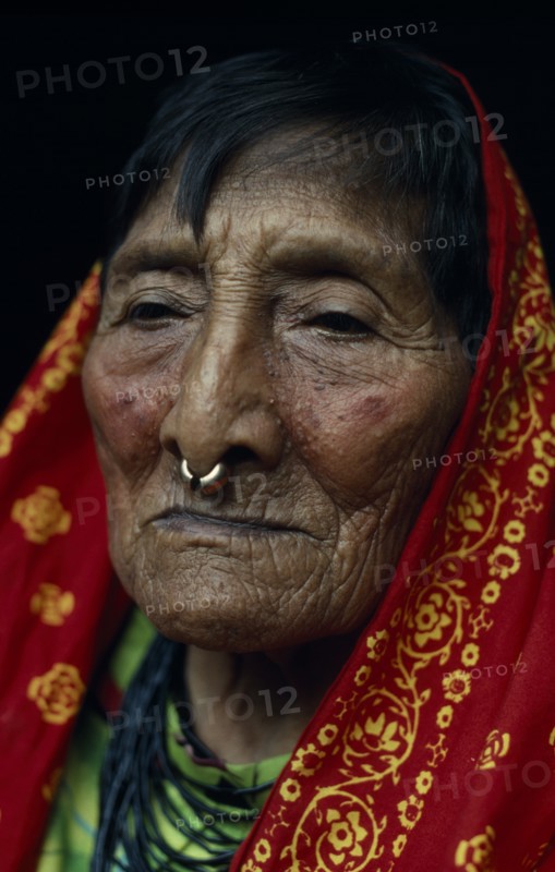 PANAMA, San Blas Islands, Kuna Indians, Head and shoulders portrait of elderly Kuna woman wearing long head scarf and traditional gold nose ring. Cuna Caribbean American Central America Classic Classical Female Women Girl Lady Hispanic Historical Latin America Latino Old Senior Aged Older Panamanian West Indies