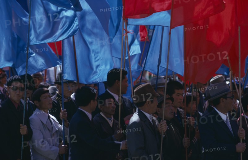 MONGOLIA, Ulan Bator, "Nadam  National Day Parade of workers and party members carrying red and blue banners, the two prime national colours.  Ulaan Baatar  Soviet Mongolia East Asia Asian Baator Male Man Guy Mongol Uls Mongolian "