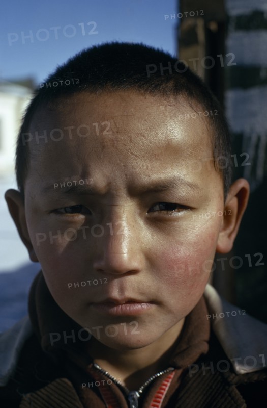 MONGOLIA, Altai town, Head and shoulders portrait of strong young Khalkha boy looking direct to camera. face on East Asia Asian Kids Mongol Uls Mongolian