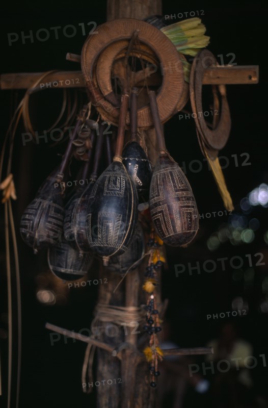 COLOMBIA, North West Amazon, Tukano Indigenous People, Makuna dancing regalia hanging from central house post engraved maracas  toucan feather crowns and nutshell rattles. Tukano Makuna Indian North Western Amazonia American Colombian Columbia Hispanic Indegent Latin America Latino Religion South America Tukano
