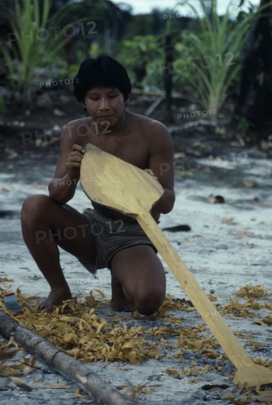 COLOMBIA, North West Amazon, Tukano Indigenous People, Makuna man making a typical Vaupes canoe paddle  short and broad blade to assist paddling through fast and dangerous rapids. Tukano  Makuna Indian North Western Amazonia American Colombian Columbia Hispanic Indegent Latin America Latino Male Men Guy South America Tukano