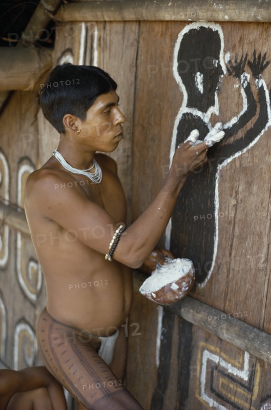 COLOMBIA, North West Amazon, Tukano Indigenous People, Cropped shot of Barasana Indian painting spirit guardian on front of maloca  communal home. Tukano sedentary tribe Indian North Western Amazonia maloca American Colombian Columbia Hispanic Indegent Latin America Latino Religion South America Tukano One individual Solo Lone Solitary Religious