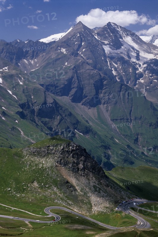 AUSTRIA, Hohe Tauern, Glockner Group  , "View towards Glockner Group and the Grossglockner Road from Edelweisse-spitze view point.  Jagged points with snow lying in crevices of peaks, grassy lower slopes. "