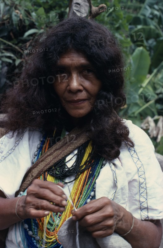 COLOMBIA, Sierra Nevada de Santa Marta, Ika, Portrait of Ika woman  one of the powerful Villafana family living in the Guatapuri river valley on the South side of the Sierra. Wearing multiple necklaces of brightly coloured glass beads  a sign of wealth. Arhuaco Aruaco indigenous tribe  Arhuaco Aruaco indigenous tribe American Colombian Colored Columbia Female Women Girl Lady Hispanic Indegent Latin America Latino One individual Solo Lone Solitary South America 1 Female Woman Girl Lady Single unitary