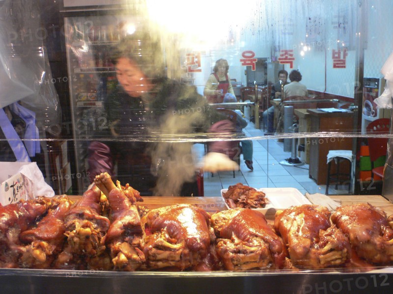 KOREA, South, Seoul, "Namdaemun - Namdaemun market, outside a roast pork restaurant, woman cutting pork"