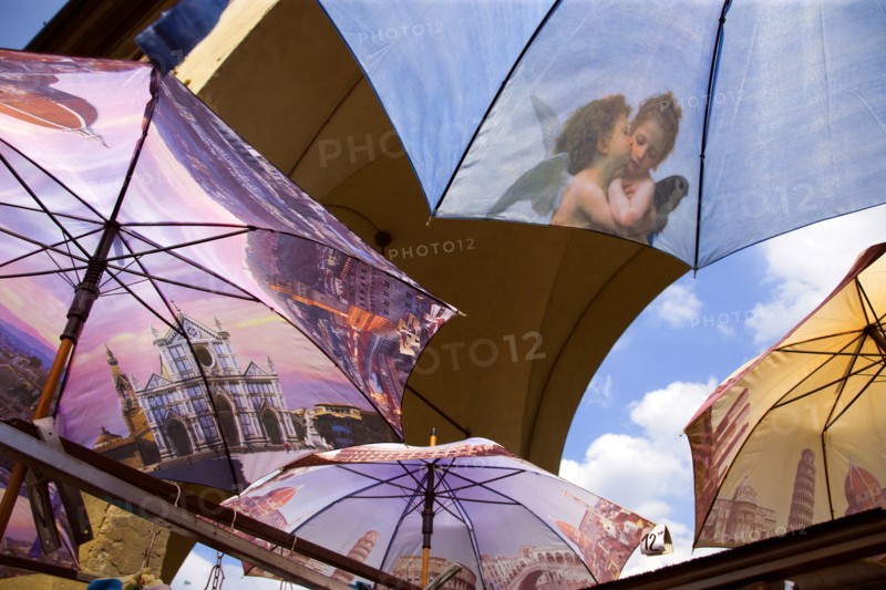 ITALY, Tuscany, Florence, Brightly coloured umbrellas for sale on the Ponte Vecchio with images of Florence and cherubs on them