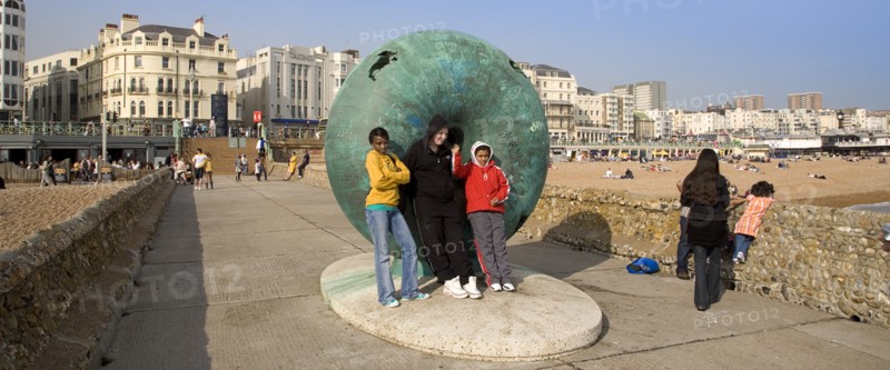 ENGLAND, East Sussex, Brighton, Tourists posing for photographs next to sculture on the seafront.