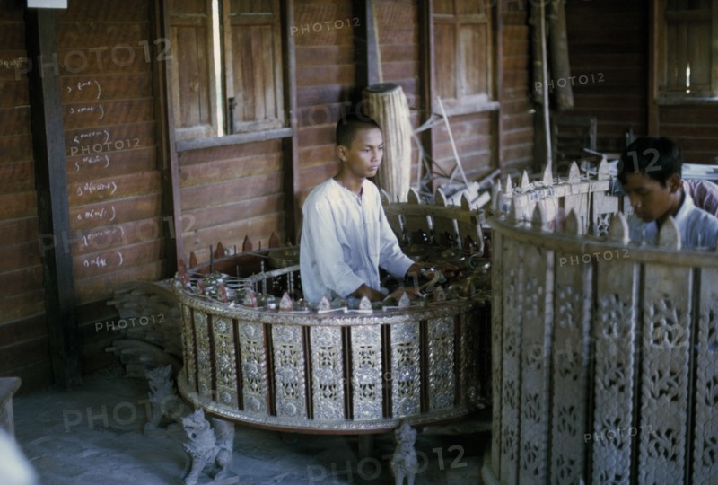 MYANMAR, Mandalay, Musician playing Pat Waing drum circle.