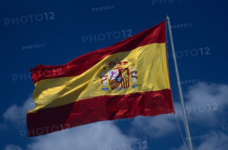 SPAIN, Pais Valenciano, Costa Blanca, Alicante.  Spanish flag flying against blue sky and white clouds.