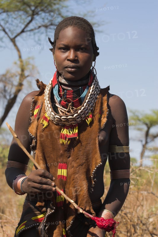ETHIOPIA, Lower Omo Valley, Tumi, "Dombo village, Hamer lady holding spoon she has used to stir cows bood ready for drinking"