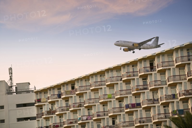 SPAIN, Balaeric Islands, Ibiza, Eivissa. Charter flight coming into land at Ibiza airport (Aeroport d'Eivissa) with tourist hotel in the foreground. Jon Hicks.