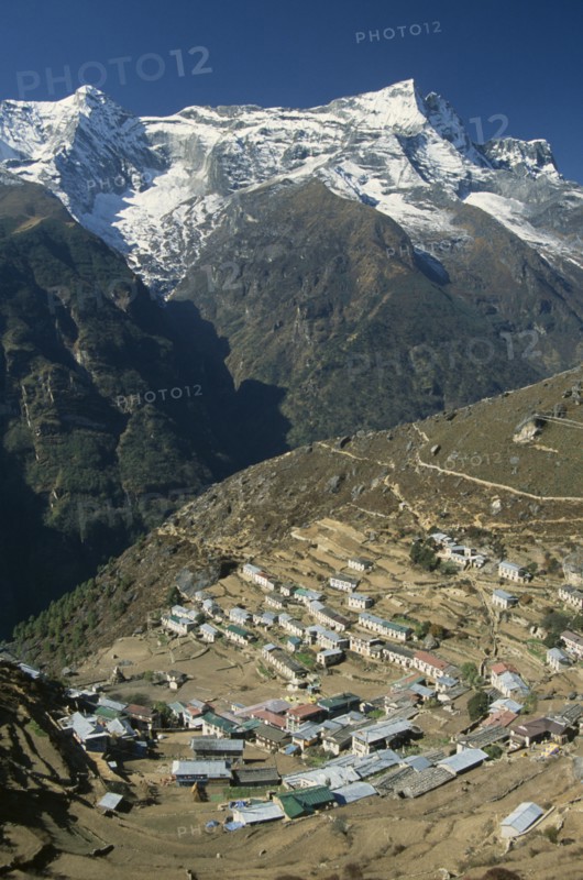 NEPAL, Everest Trek, Namche Bazaar, Elevated view over village rooftops of Namche Bazaar with Kwangde Himal mountain in the background