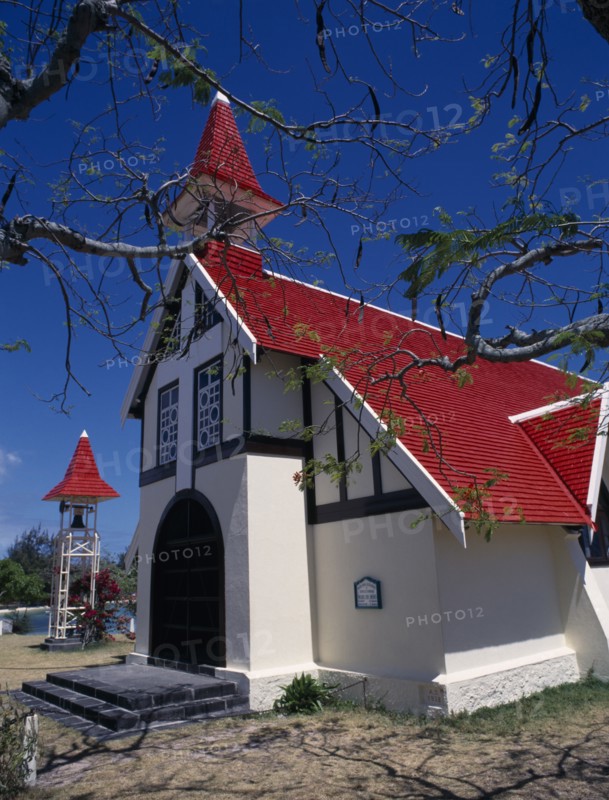 MAURITIUS, North, Poudre d’Or, "Marie-Reine Church.  White painted exterior with red tiled roof and free standing bell tower, part framed by tree branches."