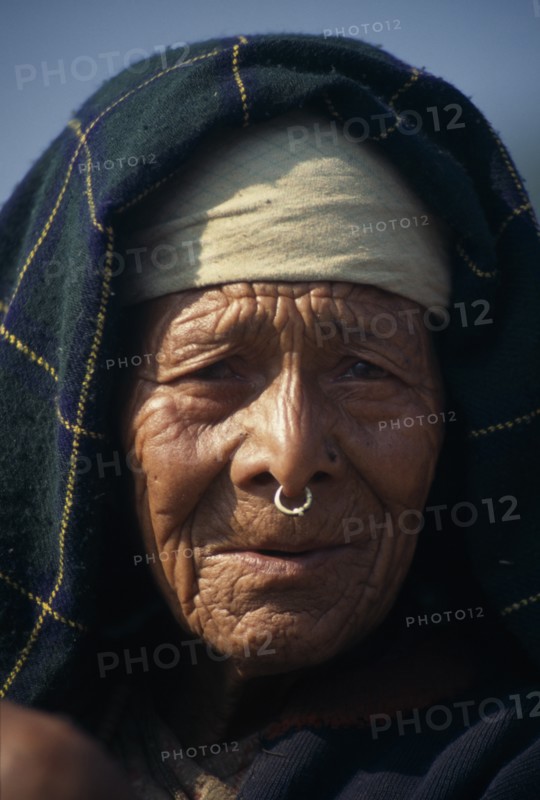 NEPAL, Dhorpatan Trek, Near Sibang, Head and shoulders portrait of elderly woman wearing a nose ring in Maachhim Village