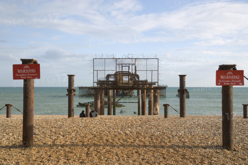 ENGLAND, East Sussex, Brighton, Ruins of the West Pier with warning signs.