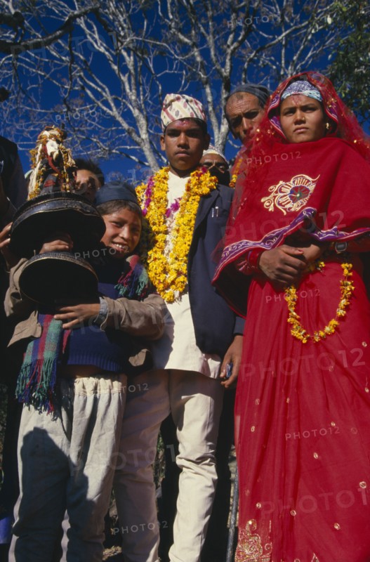 NEPAL, East,  Sangawa Khola, Bride and groom during wedding procession. Groom wearing a marigold garland and bride dressed in red.