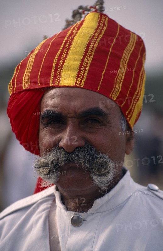 INDIA, Rajasthan, Bikaner, Head and shoulders portrait of a Rajput man with a moustache wearing a turban at the Camel Festival