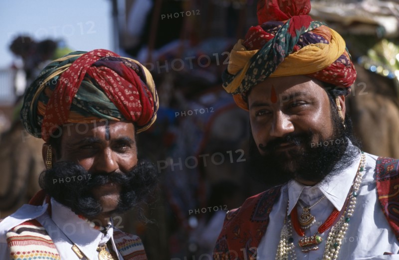 INDIA, Rajasthan, Bikaner, Two Rajput men with beards wearing ceremonial dress and turbans at the start of the Camel Festival