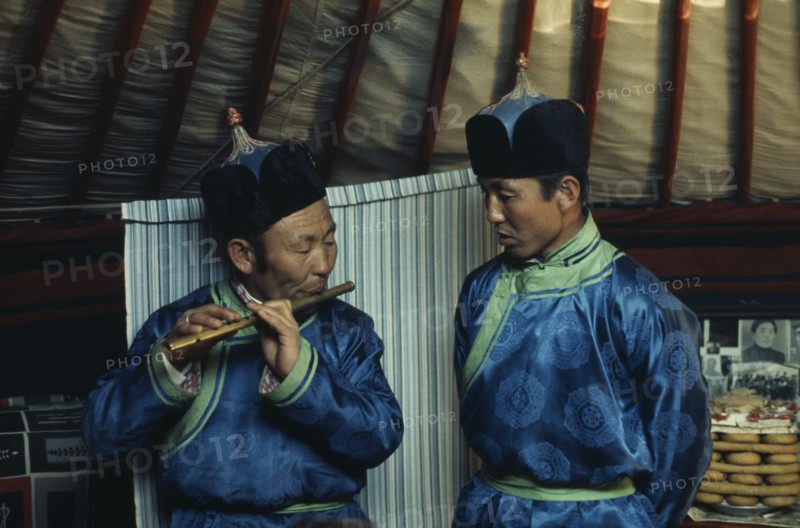 MONGOLIA, Gobi Desert, Biger Negdel, Flute player and chanter in fine traditional silk tunics during celebrations for the Mongolian Lunar New Year or Tsagaan Tsaar.  East Asia Asian Classic Classical Historical Mongol Uls Older