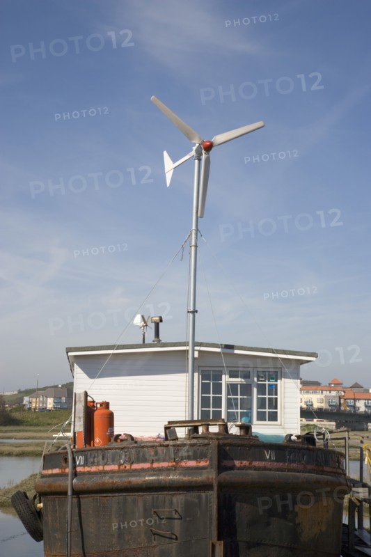 ENGLAND, West Sussex, Shoreham-by-Sea, "Houseboat, with large wind turbine in the deck, moored along the banks of the river adur. Wind turbine to generate electricity for the vessel."