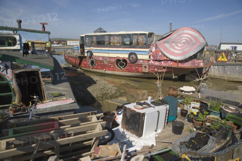 ENGLAND, West Sussex, Shoreham-by-Sea, "Houseboat moored along the banks of the river adur.  Former barges converted into homes with the use of various bits of junk, including cars, buses and washing machines."