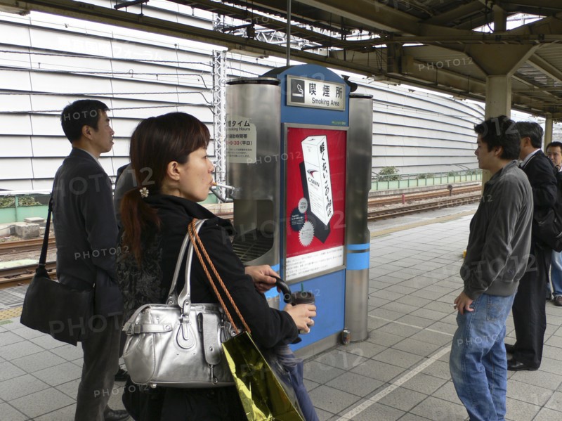 JAPAN, Honshu, Tokyo, "Yurakucho - the smokers spot on the train platform, men and a young woman smoking"