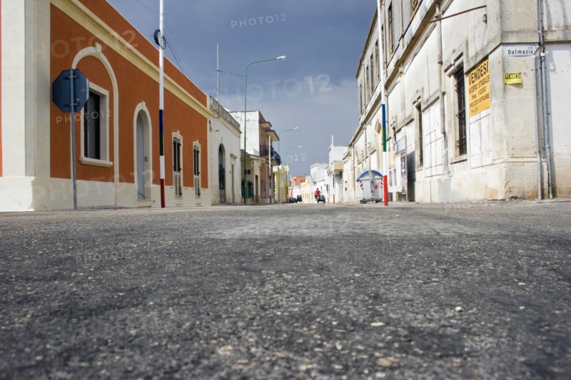 ITALY, South, Characteristic empty street lined with old coloured buildings.  Low angle shot from tarmac level.