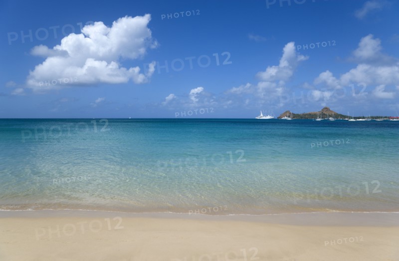 WEST INDIES, St Lucia, Gros Islet, View out to sea from Reduit Beach in Rodney Bay towards Pigeon Island with yachts at anchor in the bay