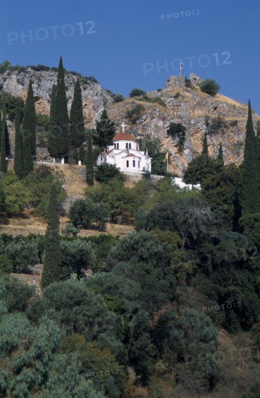GREECE, Peloponnese, Molai , White church with red tilled dome on tree covered hillside