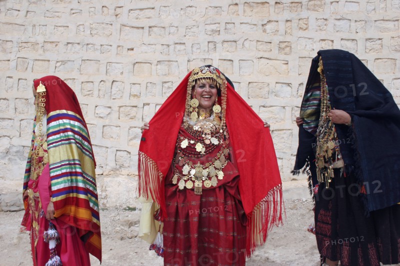 TUNISIA, Sahara, Tozeur, "Three Tunisian women wearing traditional dress, golden jewelry and ornaments, relatives of a Tunisian bride whose wedding they are celebrating on the borders of the Sahara Desert."