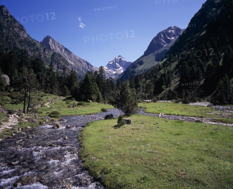 FRANCE, Midi-Pyrenees, Hautes-Pyrenees, Vallee de Lutour.  View south over lower valley with central snow covered peak of Pic de Labas 2927 m / 9586 ft south of Cauterets.  Sparkling river and trees.