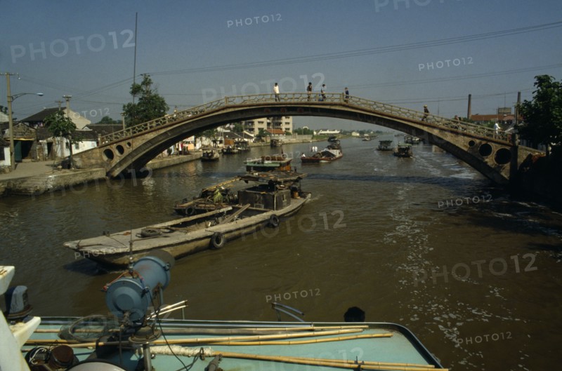 CHINA, Jiangsu Province, Transport, Barges travelling under bridge on the Grand Canal between Suzhou and Wuxi.