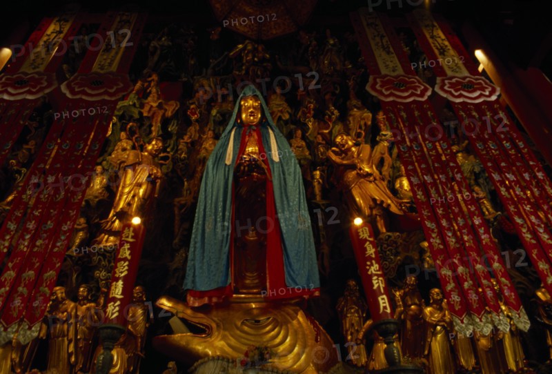 CHINA, Shanghai, Jade Buddha Temple interior with statue of standing Buddha draped in silk cloak