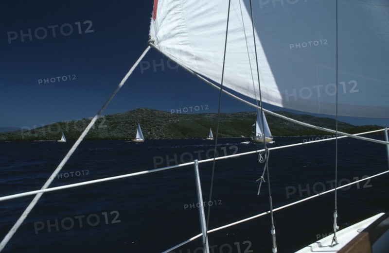 SPORT, Water Sport, Sailing, Flotilla sailing Cobra 850’s. View from deck of yacht with section of white sail on the South Ionian Sea