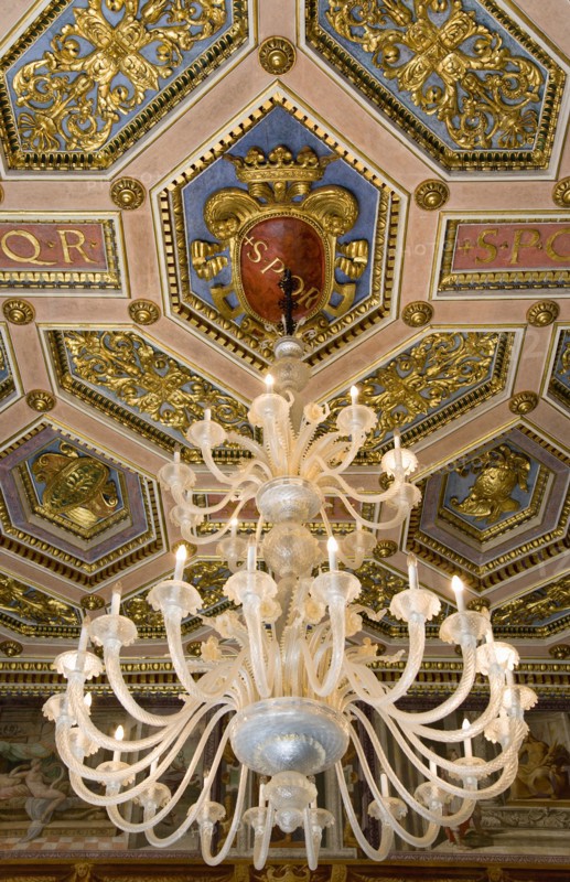 ITALY, Lazio, Rome, Capitoline Museum Palazzo Dei Conservatore chandelier hanging from the ceiling in the Palace with SPQR visible on the ornately decorated ceiling