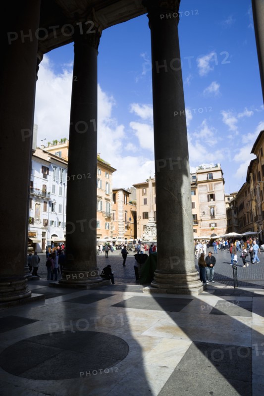 ITALY, Lazio, Rome, Piazza della Rotonda seen through the granite columns of the Pantheon with tourists walking in the square