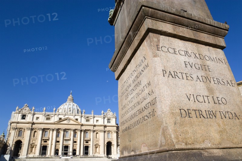 ITALY, Lazio, Rome, Vatican City The Basilica of St Peter with tourists at the entrance and a detail of the base of the Obelisk in the foreground