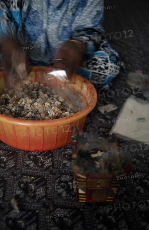 OMAN, Salalah, Trader bagging up frankincense for sale in souk.