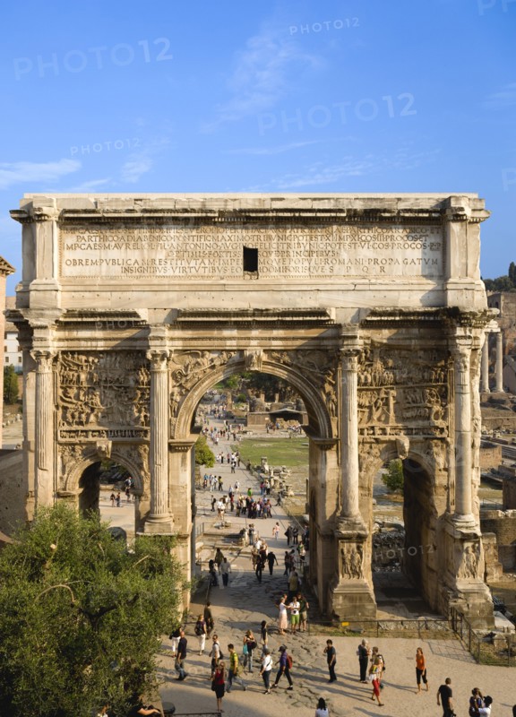 ITALY, Lazio, Rome, Tourists walking around the triumphal Arch of Septimus Severus in the Forum