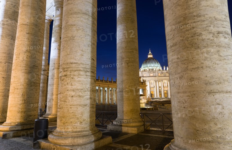 ITALY, Lazio, Rome, Vatican City The Basilica of St Peter seen through the pillars of the Ccolonnade by Bernini illuminated at night