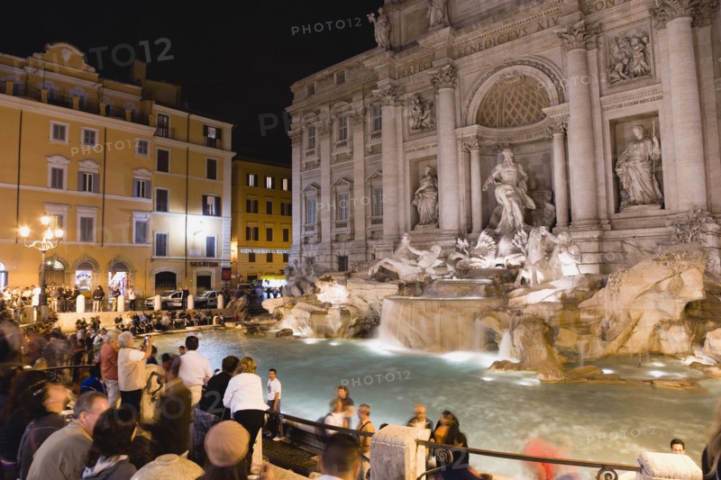 ITALY, Lazio, Rome, The 1762 Trevi Fountain by Nicola Salvi illuminated at night with tourists in the Piazza Di Trevi