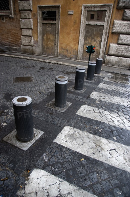 ITALY, Lazio, Rome, Automatic rising bollards and a pedestrian crossing in a side street with red and green traffic control lights