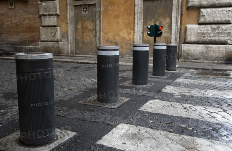 ITALY, Lazio, Rome, Automatic rising bollards and a pedestrian crossing in a side street with red and green traffic control lights