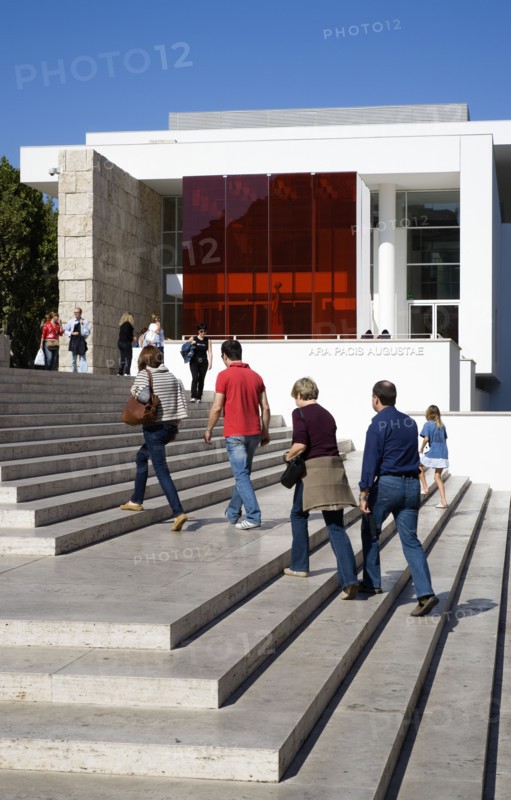 ITALY, Lazio, Rome, The steps with sightseers leading to the building hosuing the Ara Pacis or Altar of Peace built by Emperor Augustus to celebrate peace in the Mediteranean. The red prespex cube is part of a Valentino fashion exhibition at the museum