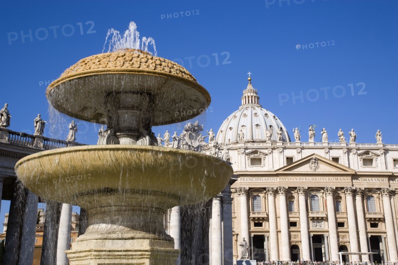 ITALY, Lazio, Rome, Vatican City The facade of the Basilica of St Peter with a water fountain and the colonnade by Bernini in the foreground