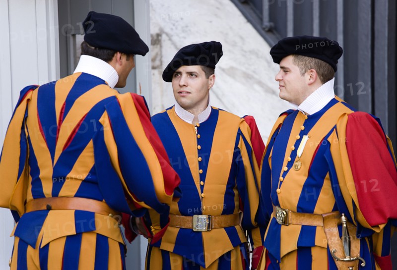 ITALY, Lazio, Rome, Vatican City Three Swiss Guards in full ceremonial uniform dress in conversation