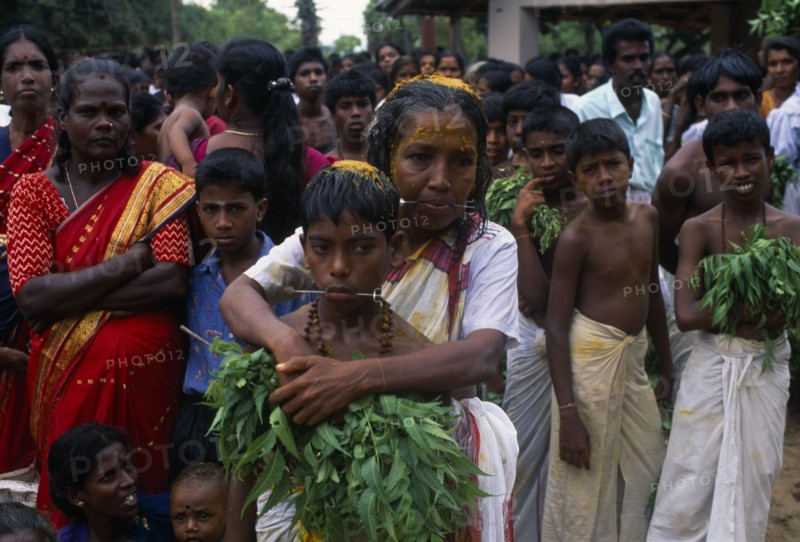 SRI LANKA, Religion, Hinduism, "Punnaccolai Festival. Tamil Oracle named Sothimalar with her arms wrapped around her son, both with ritual trident piercings inserted through cheeks"